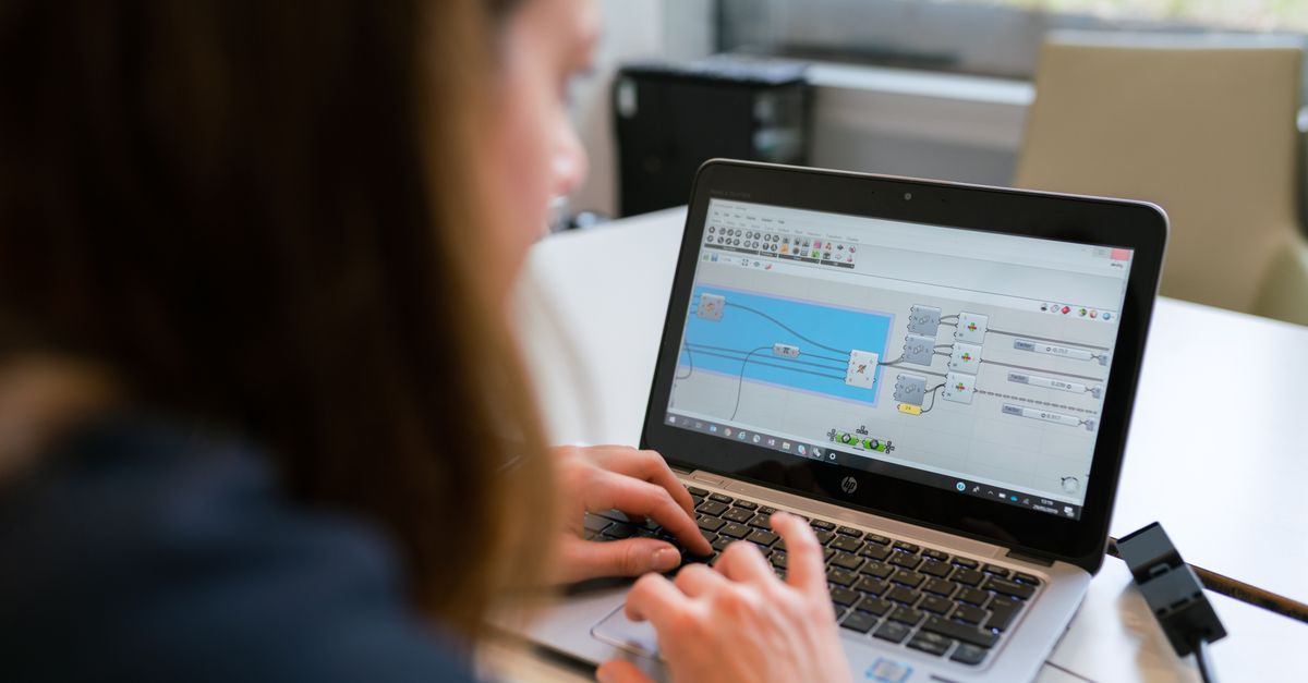Une ingénieure se concentre sur l'analyse de logiciels en utilisant un ordinateur portable à l'intérieur.